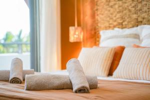 a bed with four rolled up towels on it at T2 Ocean Cottage avec terrasse - 50m de la plage in Étang-Salé