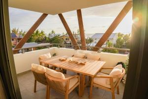 a balcony with a wooden table and chairs at T2 Ocean Cottage avec terrasse - 50m de la plage in Étang-Salé