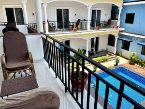 a balcony with a view of a house with a swimming pool at Morjim Sunset Hotel in Morjim