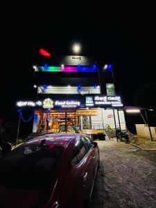 a car parked in front of a gas station at night at Subhiksha Rooms in Bellūru