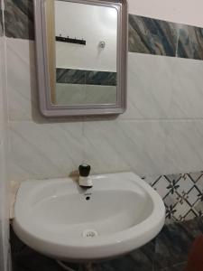 a white sink in a bathroom with a mirror at Subhiksha Rooms in Bellūru +12 photos