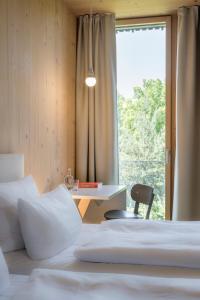 a room with two beds and a table and a window at Bader Hotel in Parsdorf