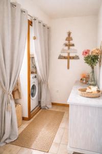 a laundry room with a washing machine and a christmas tree at Haut Doubs Belvédère in Les Hôpitaux-Neufs +7 photos