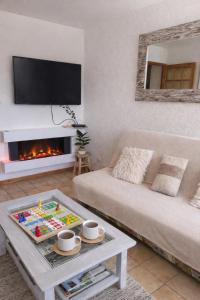 a living room with a couch and a fire place at Haut Doubs Belvédère in Les Hôpitaux-Neufs