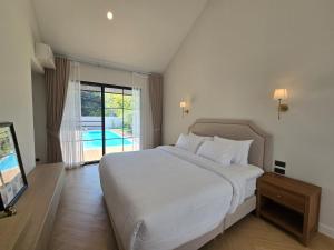 a bedroom with a large white bed and a pool at DRIZZLE pool and pillows in Phra Khanong +49 photos