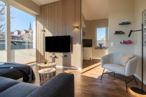 a living room with a couch and a tv at Rodehuus Wohnung 4 in Borkum