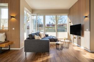 a living room with a couch and a tv at Rodehuus Wohnung 4 in Borkum