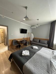 a bedroom with a bed and a couch and a television at Guest House Uzhgorod in Uzhhorod