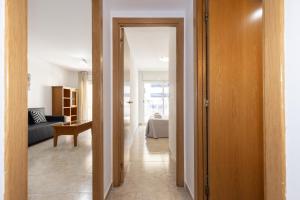 a hallway with a door leading to a living room at PINEDA NOU Apartments in La Pineda +21 photos