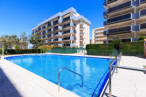 a swimming pool in front of a building at PINEDA NOU Apartments in La Pineda
