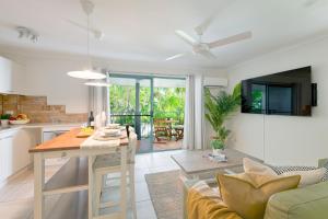 a kitchen and living room with a table and a couch at Chez Noosa Holiday Apartments in Sunshine Beach