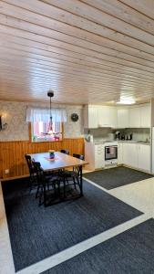 a kitchen with a table and chairs in a room at Rolig häst, Kaneeling Stugby AB in Dalskog