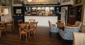 a restaurant with tables and chairs and a bar at The Caledonian New Southlands Hotel in Scarborough