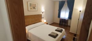 a bedroom with a bed with two towels on it at Hotel Sol de la Blanca in Cudillero