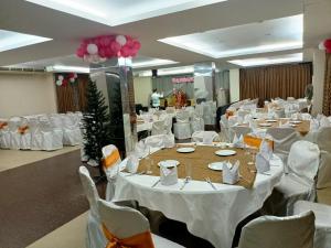 a banquet hall with white tables and white chairs at Holiday Xpress in Dhaka