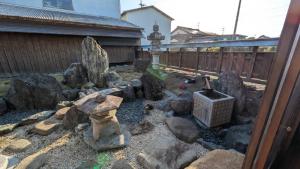 a model of a garden with rocks and a grill at ゲストハウスすまいるさん in Iba