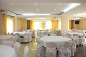 a room filled with white tables and chairs at Holiday Xpress in Dhaka