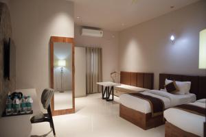 a hotel room with two beds and a mirror at Hotel Subansiri in Dibrugarh +88 photos