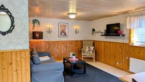 a living room with a couch and a tv at Rolig häst, Kaneeling Stugby AB in Dalskog