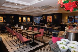 a restaurant with tables and chairs and a man in the background at Champton Hanoi Hotel in Hanoi