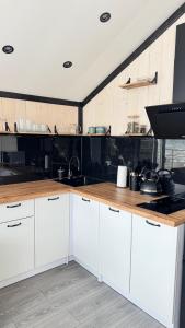 a kitchen with white cabinets and a wooden counter top at Mountain soul hub будиночок на схилі in Krasnik +14 photos