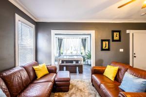 a living room with a brown couch and yellow pillows at Orange Queen LLC in East Orange