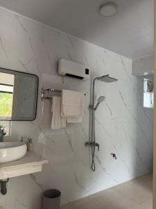 a white bathroom with a shower and a sink at Mộc Sơn Homestay in Mộc Châu +78 photos