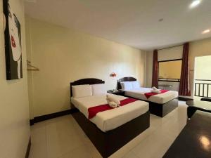 a hotel room with two beds and a couch at Hollywood Suites Gensan in General Santos +7 photos