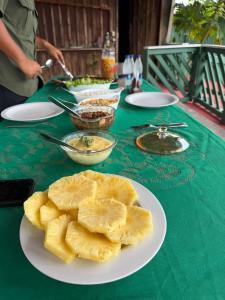 a green table with a plate of food on it at Luz Amazônia Lodge in Aiparuça