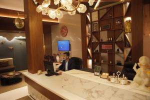 a man sitting at a desk with a laptop at Hotel Subansiri in Dibrugarh