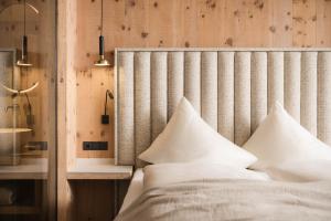 ein Bett mit weißen Kissen in einem Zimmer in der Unterkunft Forster's Naturresort in Neustift im Stubaital + 157 Fotos