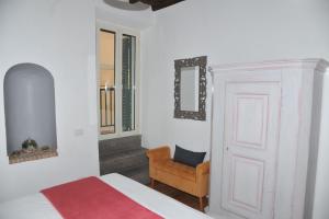 a bedroom with a bed and a chair and a mirror at Il Valentino in Castel Gandolfo