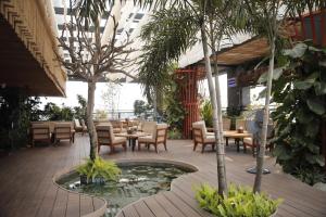 a restaurant with tables and chairs and a pond at Hotel Subansiri in Dibrugarh