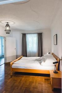 a bedroom with a large white bed with a window at KOKORO am Kirchplatz in Sankt Veit am Vogau