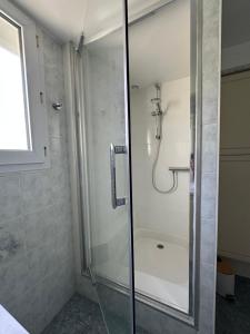 a shower with a glass door in a bathroom at Maison les Boites in La Chapelle-Rousselin