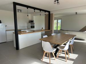 a kitchen and dining room with a wooden table and chairs at Maison les Boites in La Chapelle-Rousselin