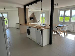 a kitchen with a sink and a washing machine at Maison les Boites in La Chapelle-Rousselin