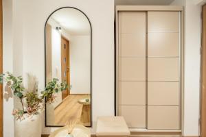 a mirror in a bathroom with a white wall at Ovideli Apartment in Ocna-Mureşului +6 photos
