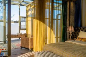 a bedroom with a bed and a yellow curtain at Wumo Qinglu Snow Mountain Museum Hotel in Baisha