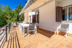 a patio with a table and chairs on a balcony at Bon Jardi in Esporlas