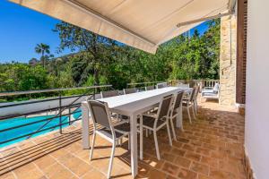 a white table and chairs on a patio with a pool at Bon Jardi in Esporlas +43 photos