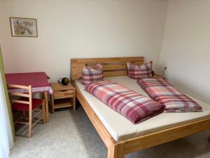 a bed with two pillows and a table in a room at Breighof in Biberach bei Offenburg