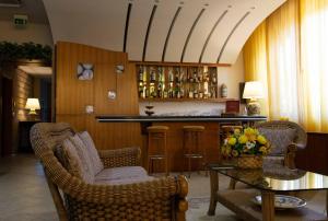 ein Wohnzimmer mit einer Bar mit Stühlen und einem Tisch in der Unterkunft Hotel Maddaloni in Tufino + 53 Fotos