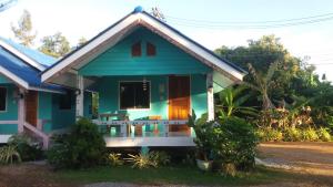 a blue house with a porch with chairs in it at Lung Teeb Paradise Chao Lao Resort in Chao Lao Beach