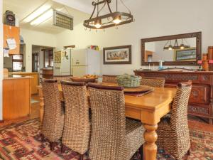 a dining room with a wooden table and chairs at Haweweg 5 in Struisbaai +5 photos