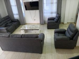 a living room with two couches and a tv at Greenwood Apartments in Mtwapa