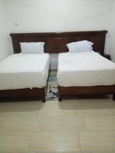 two beds sitting next to each other in a room at Greenwood Apartments in Mtwapa