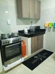 a kitchen with a stove and a counter top at Greenwood Apartments in Mtwapa