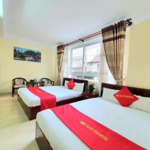 a hotel room with two beds and a window at Thanh Thao Dalat Hotel in Da Lat +19 photos