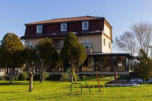 a house with a playground in front of a building at Kapija Grada in Ečka